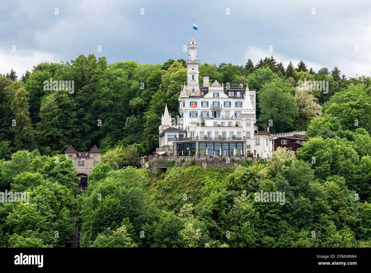 Castello bianco fiabesco arroccato su una collina densamente boscosa Foto Stock
