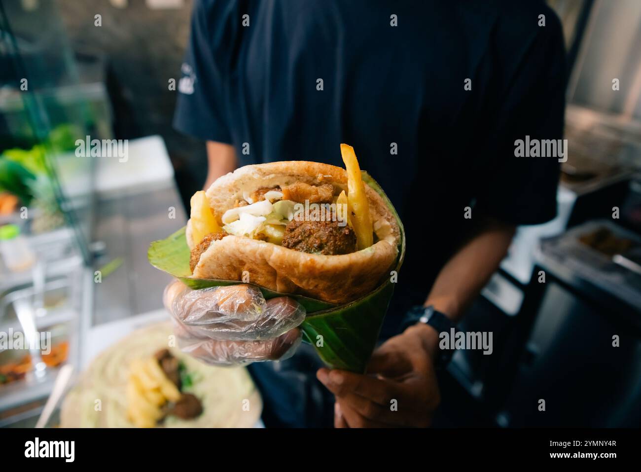 Qualcuno ha in mano shawarma di carne araba, shawarmah libanese, shawarma sandwich siriano. Foto di alta qualità Foto Stock