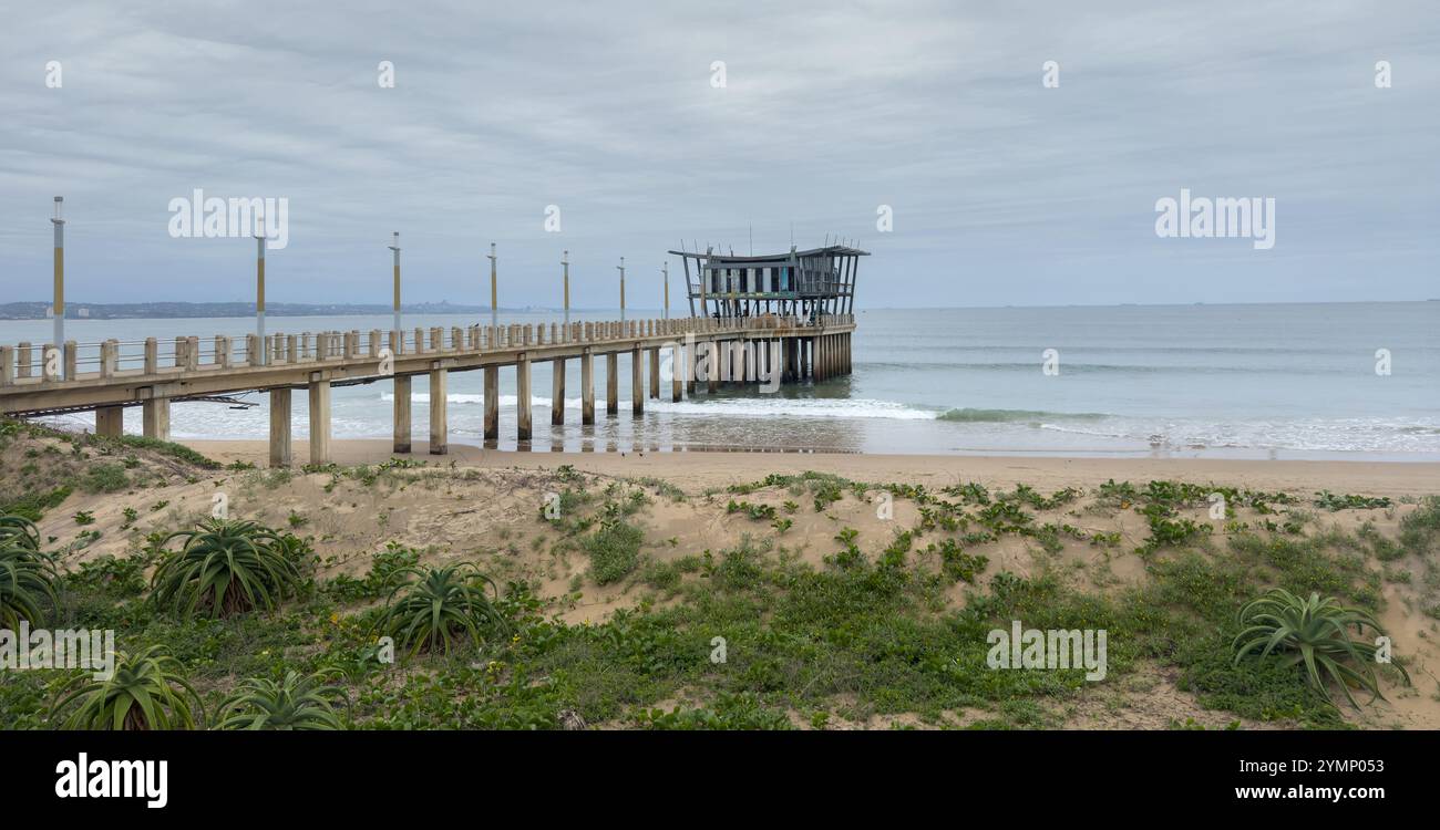 Molo sulla spiaggia di Durban Ushaka lungo la spiaggia di Golden Mile in Sud Africa, cielo nuvoloso Foto Stock