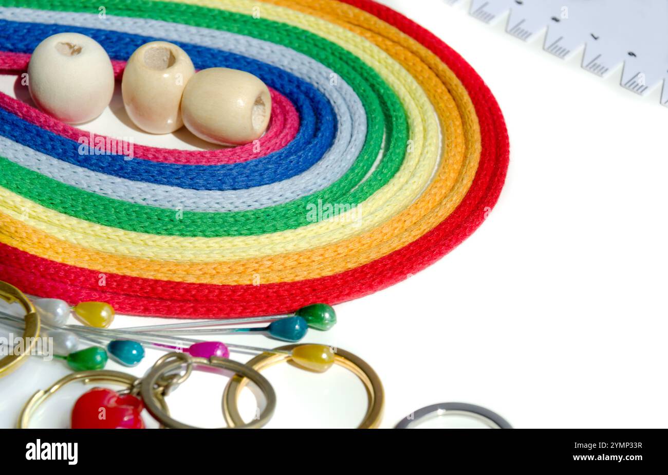 Filati di cotone. Brillante gamma arcobaleno di fili di cotone multicolore, ganci e accessori isolati su sfondo bianco. Foto Stock