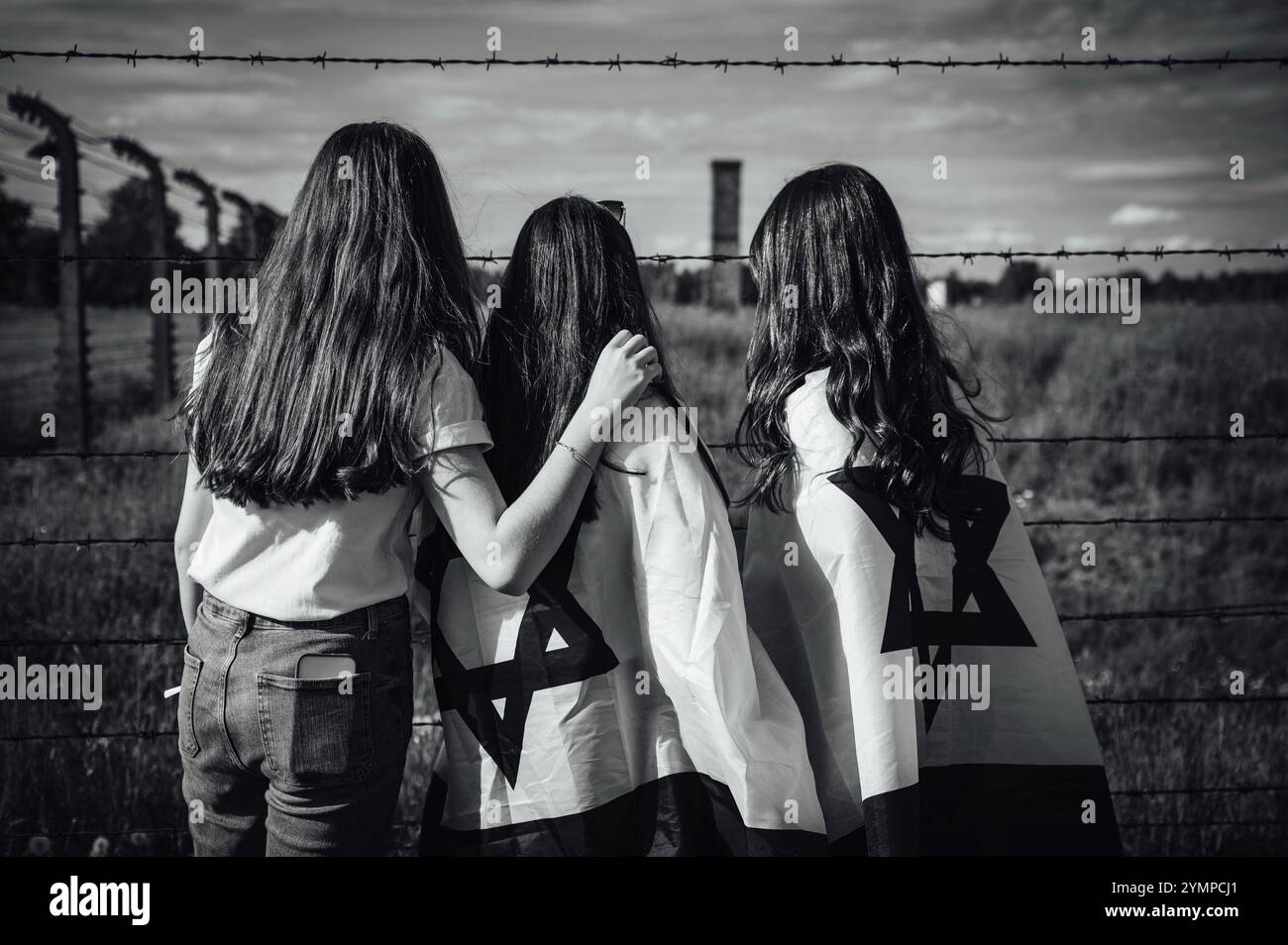 Ragazze ebree con bandiere israeliane vicino alla recinzione del campo di concentramento Foto Stock