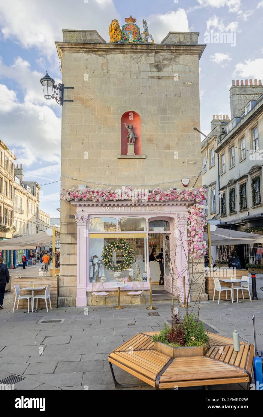 Caffè Sweet Little Things adornato con fiori rosa e corona di Natale con stufato di putto e Royal Coat of Arms nell'edificio sopra a Bath, Regno Unito, su 22 nove Foto Stock