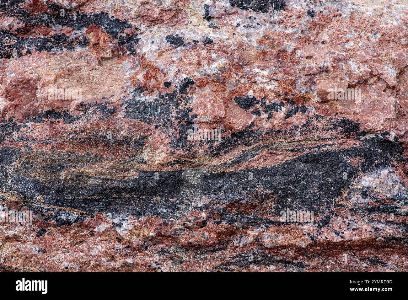 Pink Rock con venature nere che lo attraversano Foto Stock