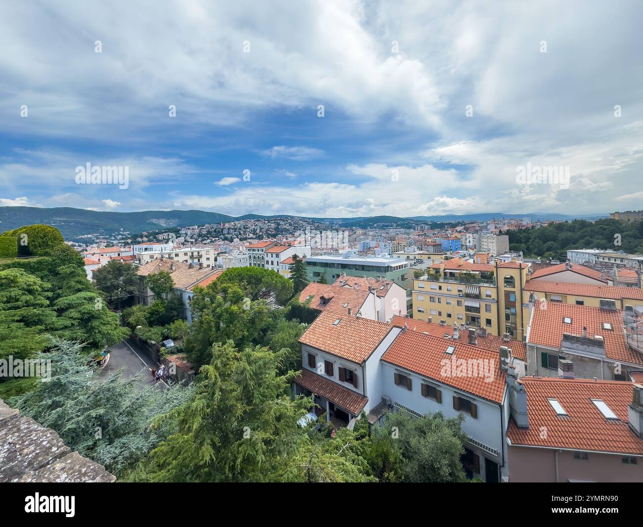 Trieste, Italia - 27 giugno 2024: Storico castello di San giusto. Paesaggio urbano che si affaccia dai bastioni se. Paesaggio urbano sotto una nuvola blu Foto Stock