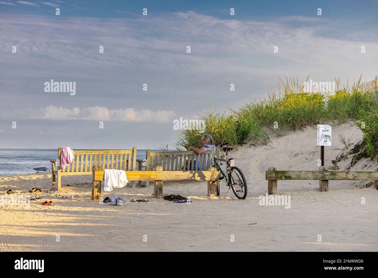 un uomo seduto su una panchina alla spiaggia di wainscott Foto Stock