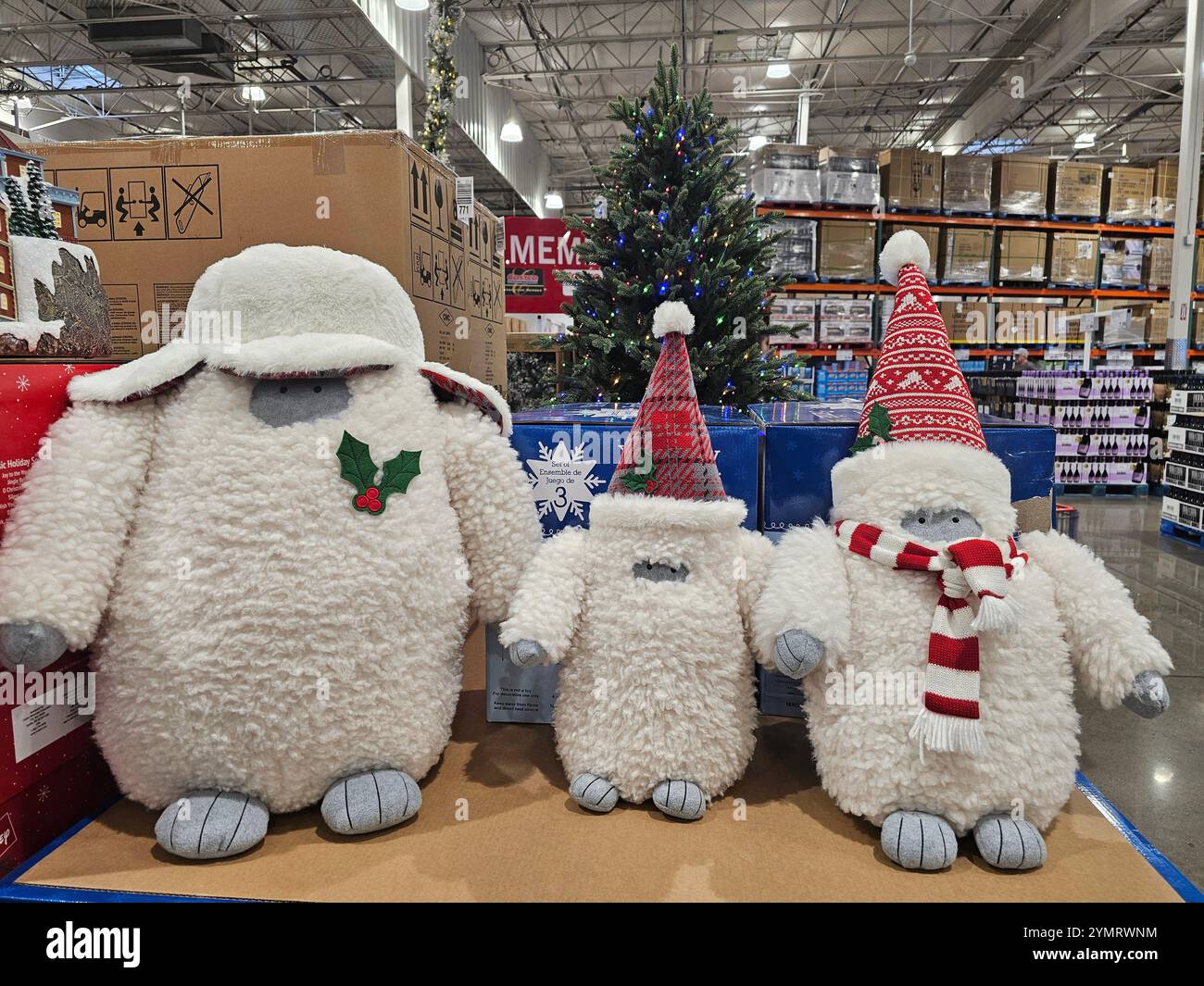 Adorabili e soffici decori natalizi di creature della neve con cappelli e sciarpe natalizie in mostra in un negozio. Perfetto per i temi dell'arredamento natalizio e. Foto Stock