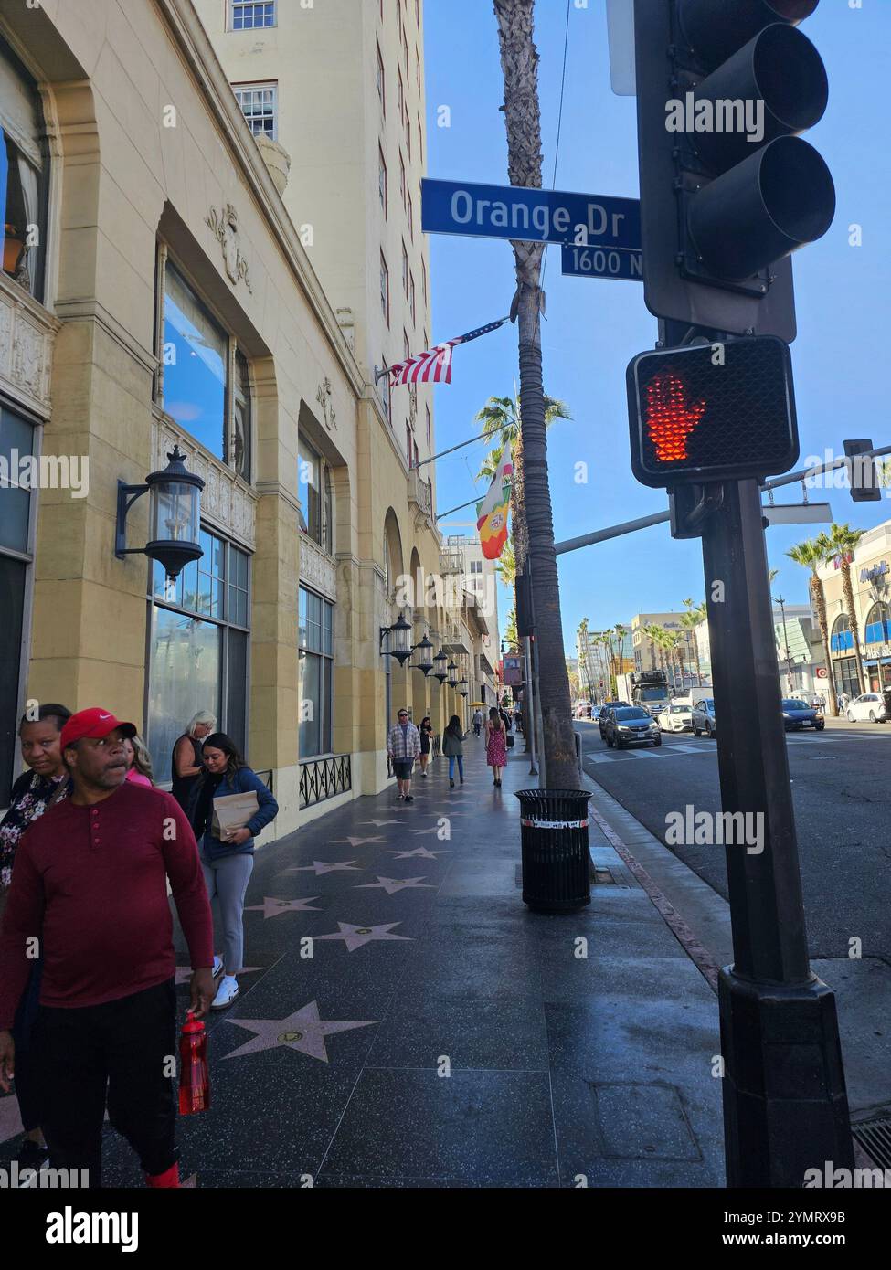"Hollywood Walk of Fame in una giornata di sole, con turisti, palme e l'iconica insegna di Orange Drive Street. Perfetto per i temi del turismo e del cit - Immagine stock catturata con smartphone