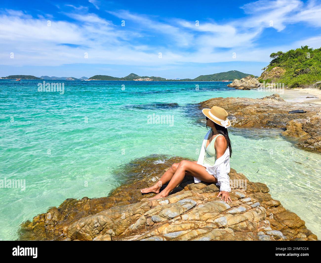 Le spiagge baciate dal sole e le acque turchesi creano una fuga serena a Samae San Island Thailandia. Una donna visitatrice si rilassa sulle rocce, godendosi il caldo, Foto Stock