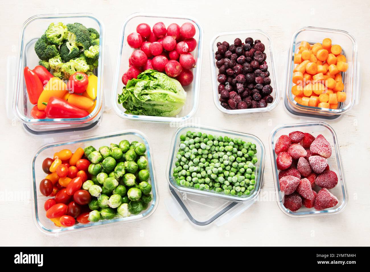 Contenitori in vetro con diversi prodotti freschi, come verdura e frutta, su uno sfondo chiaro. Vista dall'alto. Foto Stock