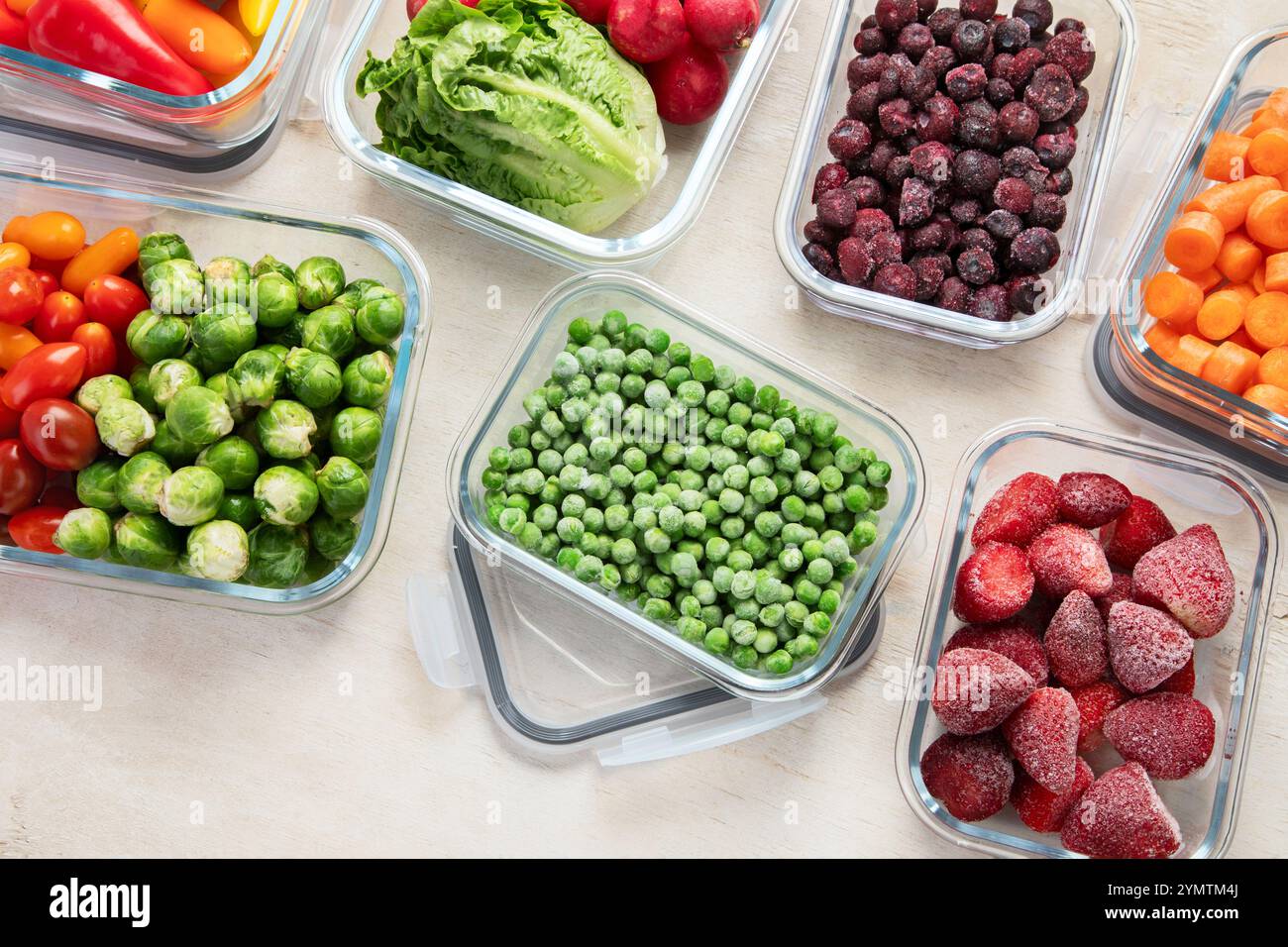 Contenitori in vetro con diversi prodotti freschi, come verdura e frutta, su uno sfondo chiaro. Vista dall'alto. Foto Stock