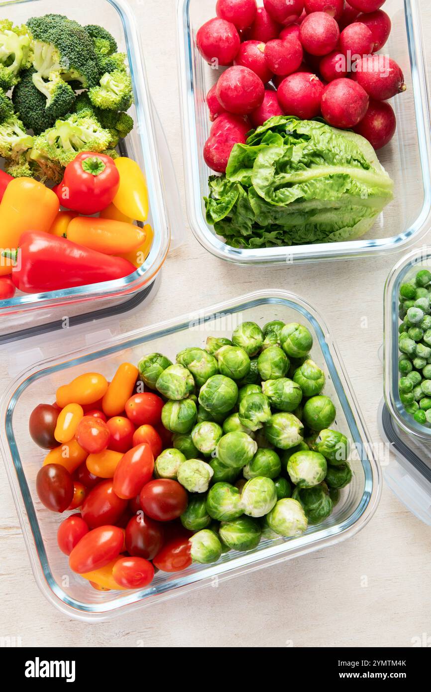 Contenitori in vetro con diversi prodotti freschi, come verdura e frutta, su uno sfondo chiaro. Vista dall'alto. Foto Stock
