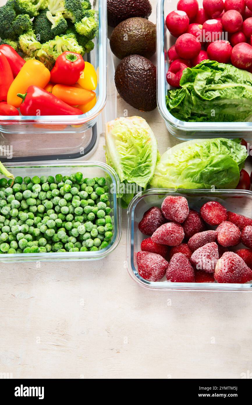 Contenitori in vetro con diversi prodotti freschi, come verdura e frutta, su uno sfondo chiaro. Vista dall'alto. Copia spazio. Foto Stock