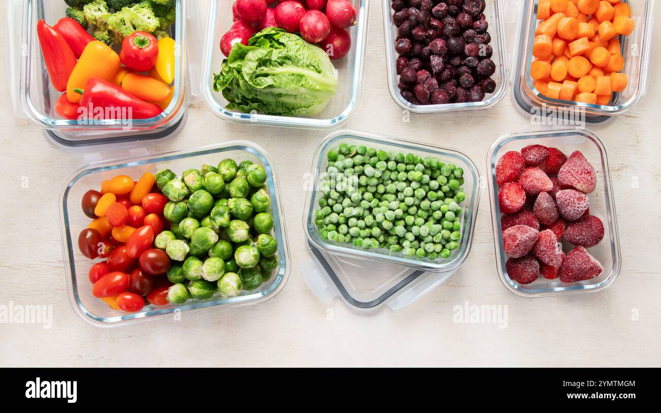 Contenitori in vetro con diversi prodotti freschi, come verdura e frutta, su uno sfondo chiaro. Vista dall'alto. Copia spazio. Foto Stock