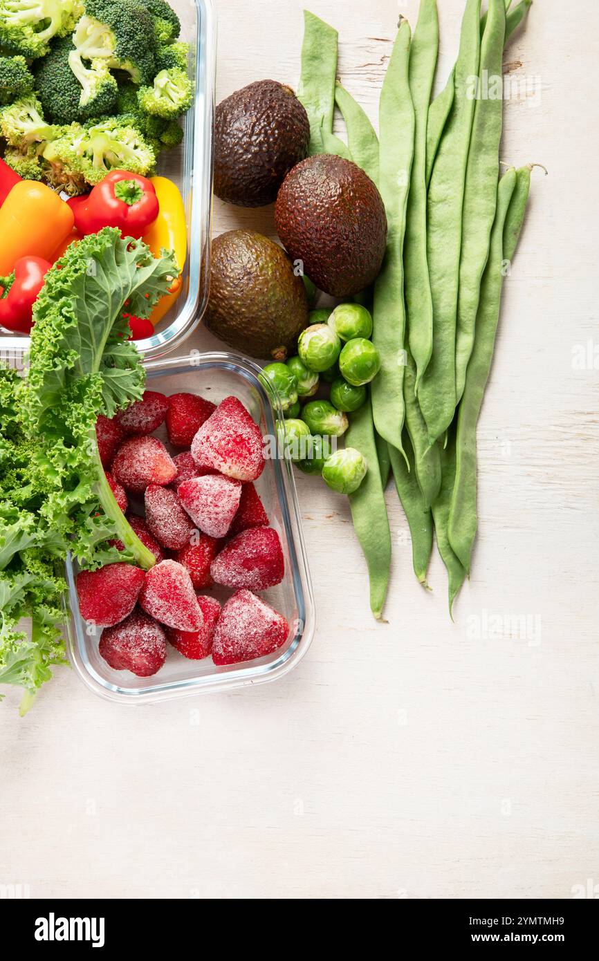 Contenitori in vetro con diversi prodotti freschi, come verdura e frutta, su uno sfondo chiaro. Vista dall'alto. Copia spazio. Foto Stock