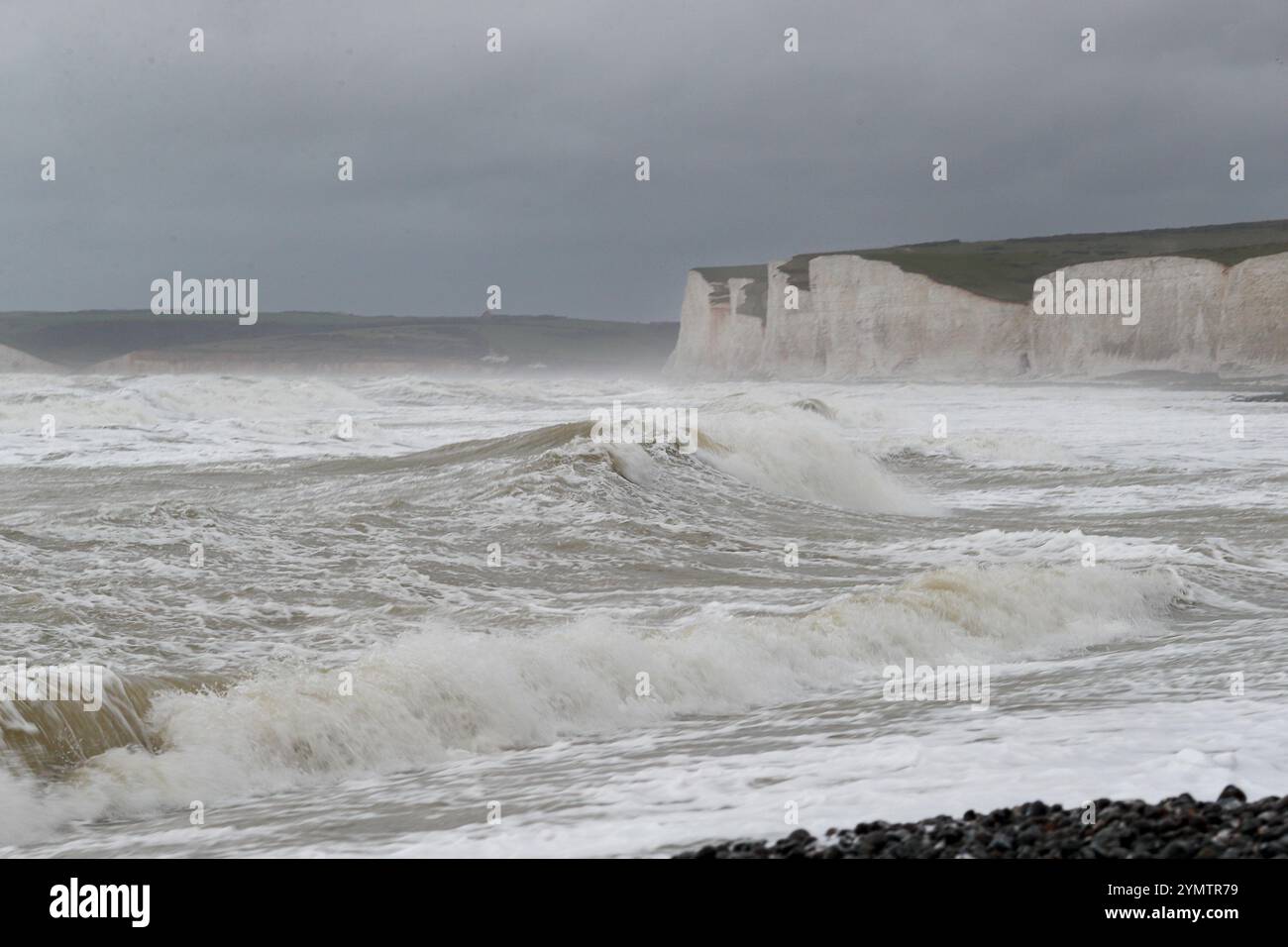 Birling Gap, Eastbourne. 23 novembre 2024. Venti di forza, grandi onde e pioggia battente hanno colpito la costa meridionale questa mattina mentre la tempesta Bert ha sbarcato. Il Met Office ha emesso un avviso meteorologico giallo per la costa meridionale dalle 15:00 alle 21:00 di oggi, mentre Storm Bert è destinato a intensificarsi. Grandi onde viste infrangersi al Birling Gap di Eastbourne, nell'East Sussex. Il sito è di proprietà del National Trust che teme che l'ultima tempesta nominata possa causare ulteriori collassi delle scogliere di gesso come visto il 23 ottobre 2024 quando una grande sezione della scogliera cadde sulla spiaggia. I visitatori sono consigliati Foto Stock