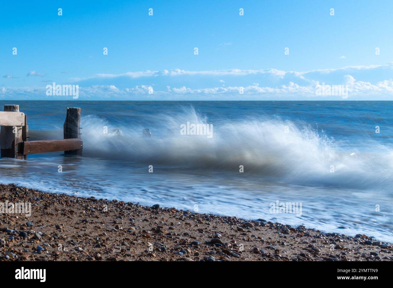 Foto a lunga esposizione delle onde su una spiaggia in un giorno di novembre soleggiato, Bexhill-on-Sea, Inghilterra Foto Stock
