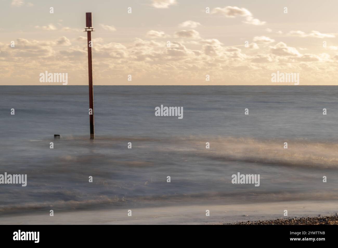 Foto a lunga esposizione delle onde su una spiaggia in un giorno di novembre soleggiato, Bexhill-on-Sea, Inghilterra Foto Stock