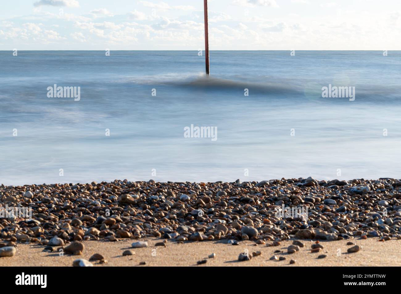 Foto a lunga esposizione delle onde su una spiaggia in un giorno di novembre soleggiato, Bexhill-on-Sea, Inghilterra Foto Stock