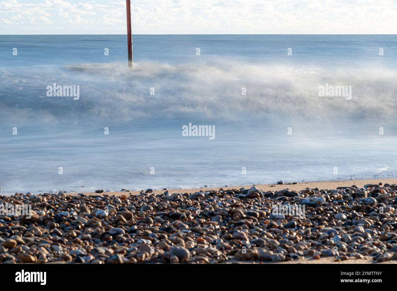 Foto a lunga esposizione delle onde su una spiaggia in un giorno di novembre soleggiato, Bexhill-on-Sea, Inghilterra Foto Stock