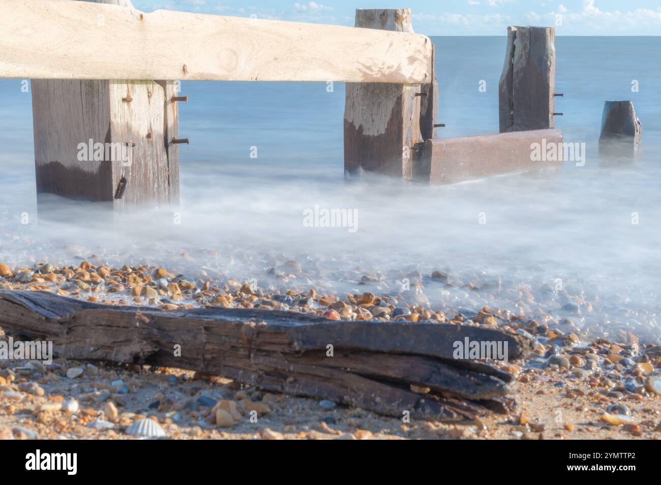 Foto a lunga esposizione delle onde su una spiaggia in un giorno di novembre soleggiato, Bexhill-on-Sea, Inghilterra Foto Stock