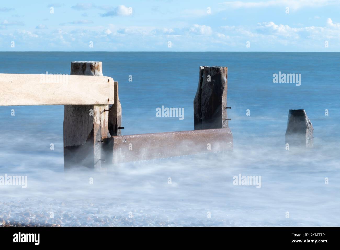 Foto a lunga esposizione delle onde su una spiaggia in un giorno di novembre soleggiato, Bexhill-on-Sea, Inghilterra Foto Stock