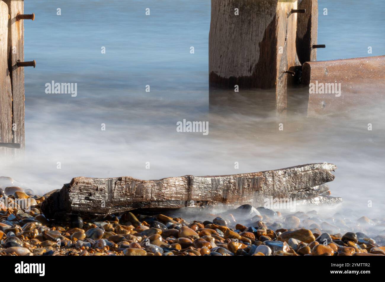Foto a lunga esposizione delle onde su una spiaggia in un giorno di novembre soleggiato, Bexhill-on-Sea, Inghilterra Foto Stock