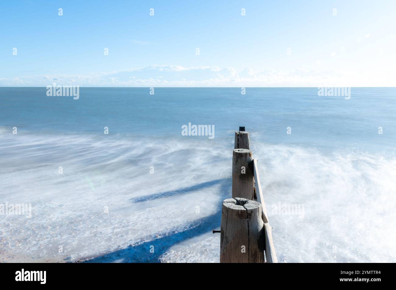 Foto a lunga esposizione delle onde su una spiaggia in un giorno di novembre soleggiato, Bexhill-on-Sea, Inghilterra Foto Stock
