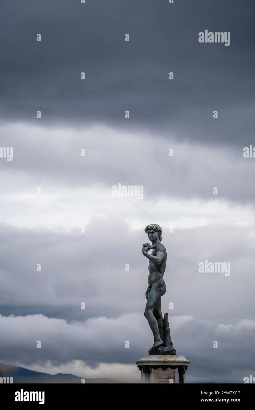 Ammira la copia in bronzo del famoso David di Michelangelo, un capolavoro della scultura rinascimentale italiana, in Piazzale Michelangelo contro le nuvole Foto Stock