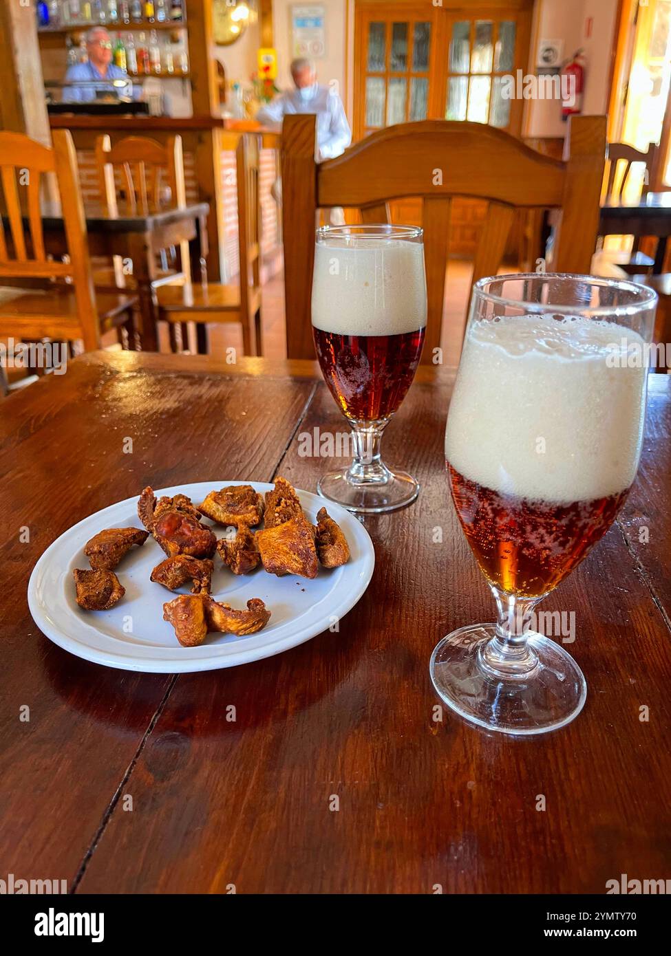 Due bicchieri di birra con torreznos come tapa. Segovia, Spagna. Foto Stock