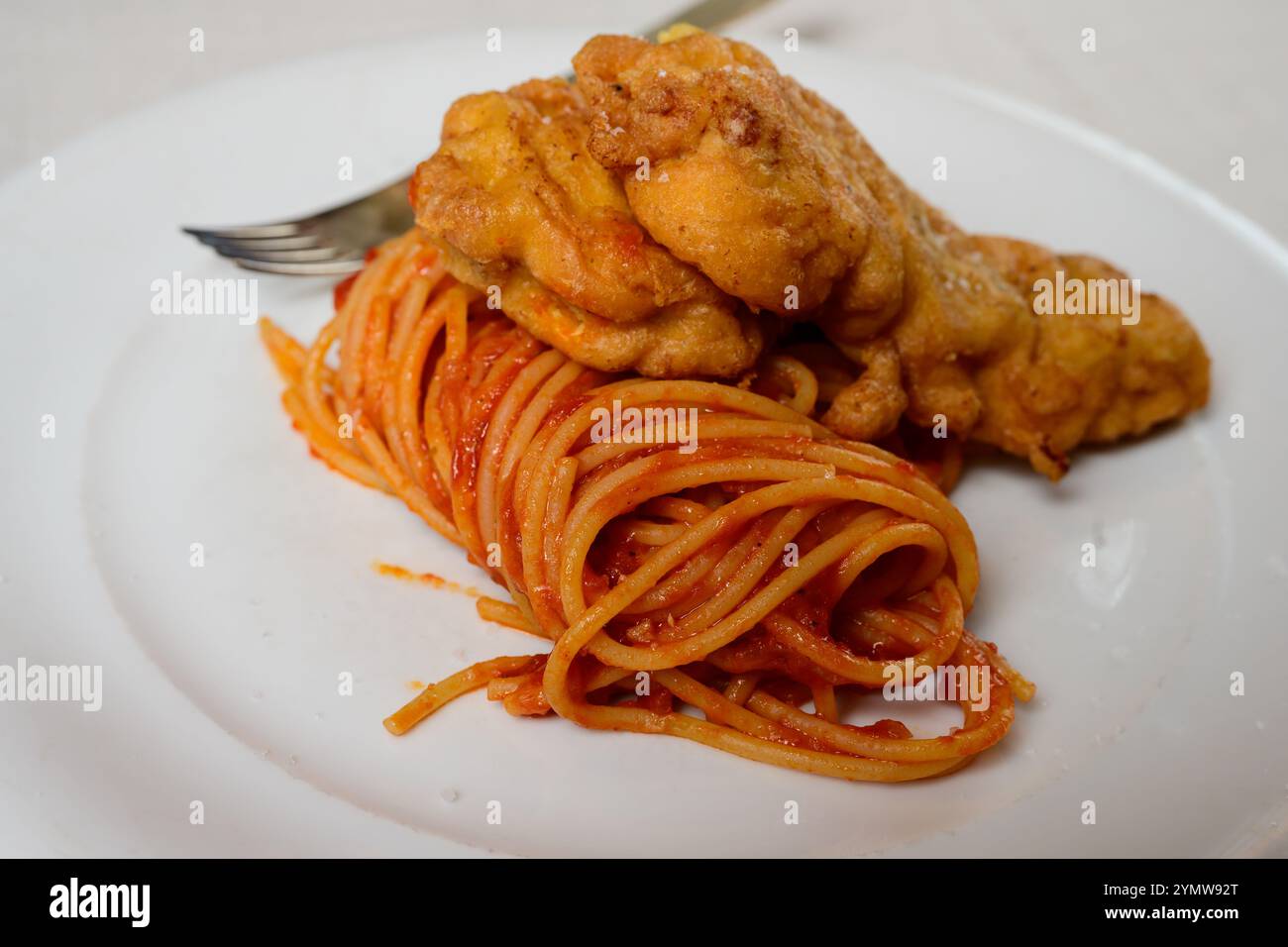 Cotoletta di vitello piccata alla milanese con spaghetti e salsa di pomodoro Foto Stock