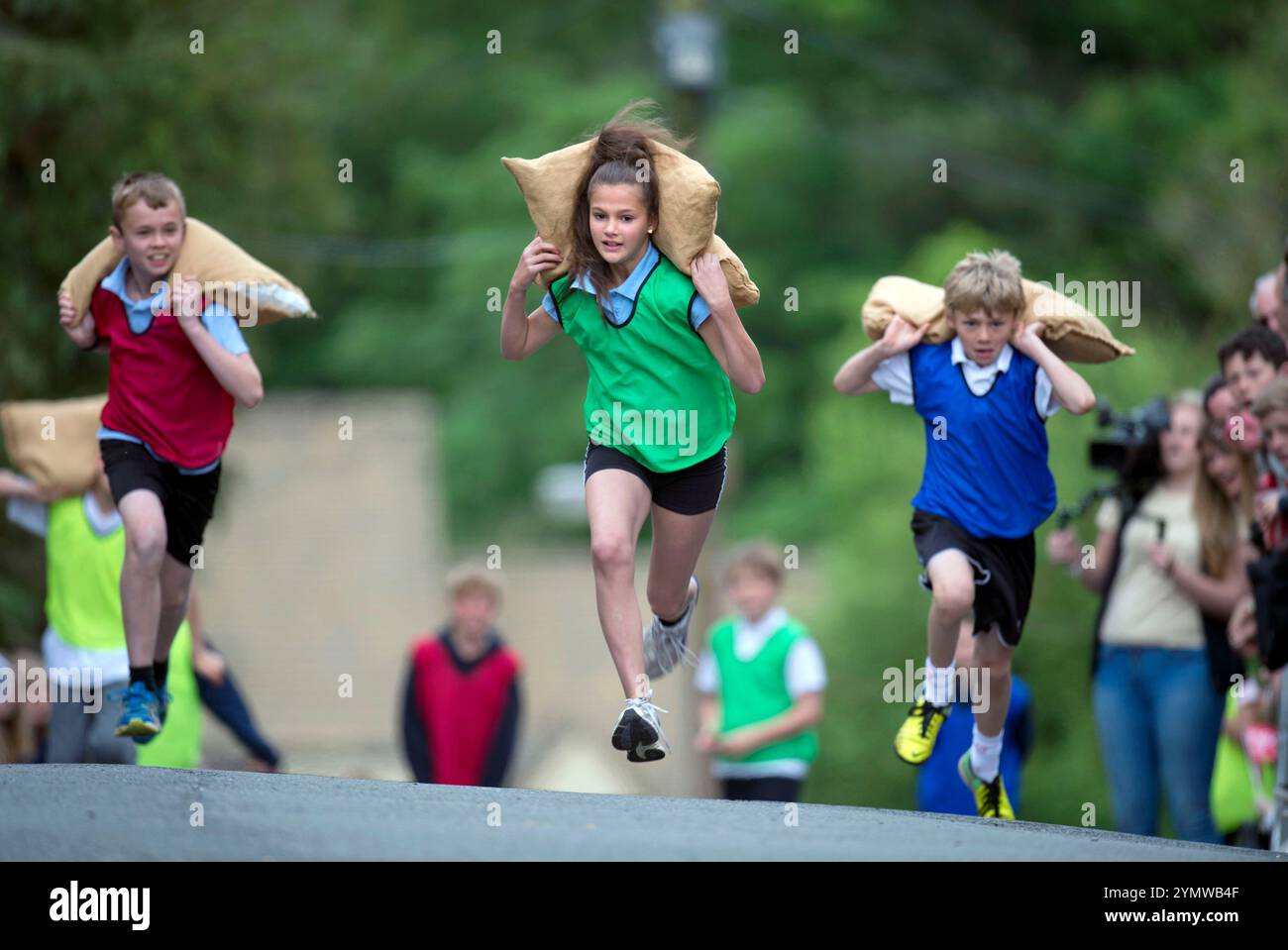 I bambini corrono su Gumstool Hill alle corse di feste Tetbury Woolsack May Bank nel Gloucestershire. Foto Stock