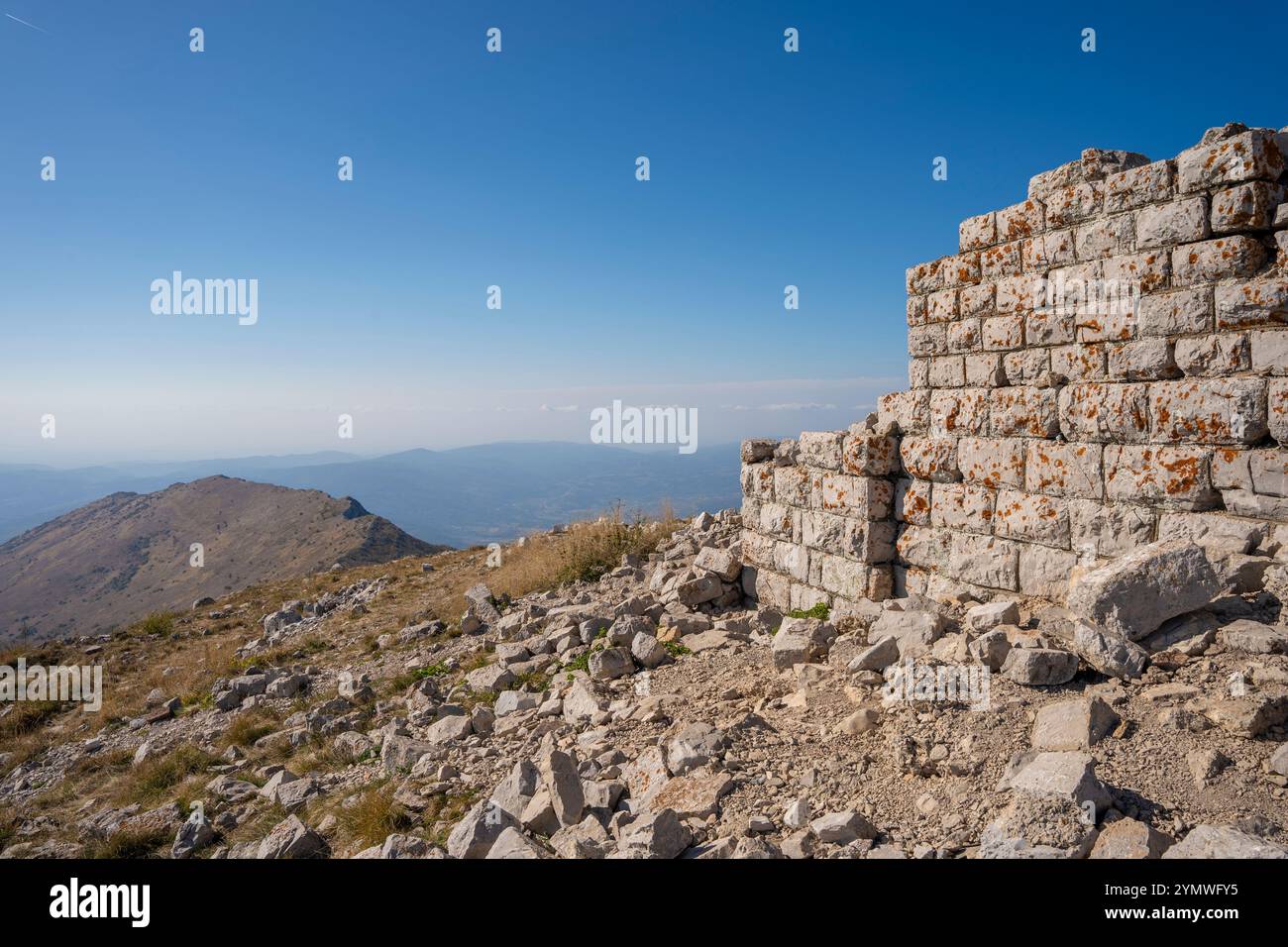 Resti di una vecchia chiesa sulla collina del monte Rtanj con un cielo nuvoloso in lontananza Foto Stock