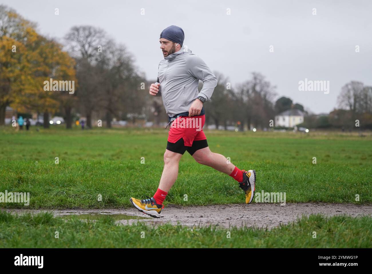 Londra, Regno Unito. 23 novembre 2024 Un jogger che corre a Wimbledon Common, a sud-ovest di Londra in condizioni di pioggia e vento mentre Storm Bert colpisce il Regno Unito. L'ufficio MET ha attivato avvisi meteo per vento, pioggia e neve in tutto il Regno Unito con 16 avvisi di inondazione e raffiche di vento fino a 70 km/h di credito . Amer Ghazzal/Alamy Live News Foto Stock