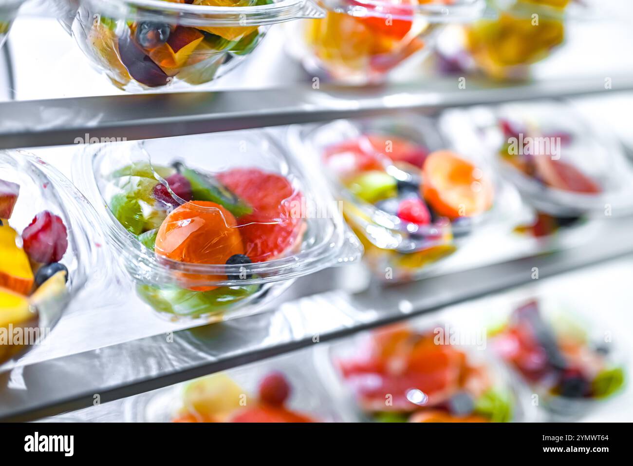 Scatole di plastica con macedonie di frutta preconfezionate, messe in vendita in un frigorifero commerciale Foto Stock
