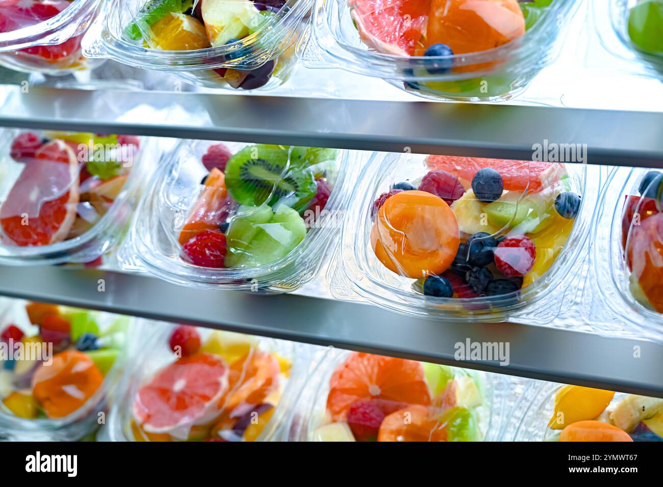 Scatole di plastica con macedonie di frutta preconfezionate, messe in vendita in un frigorifero commerciale Foto Stock