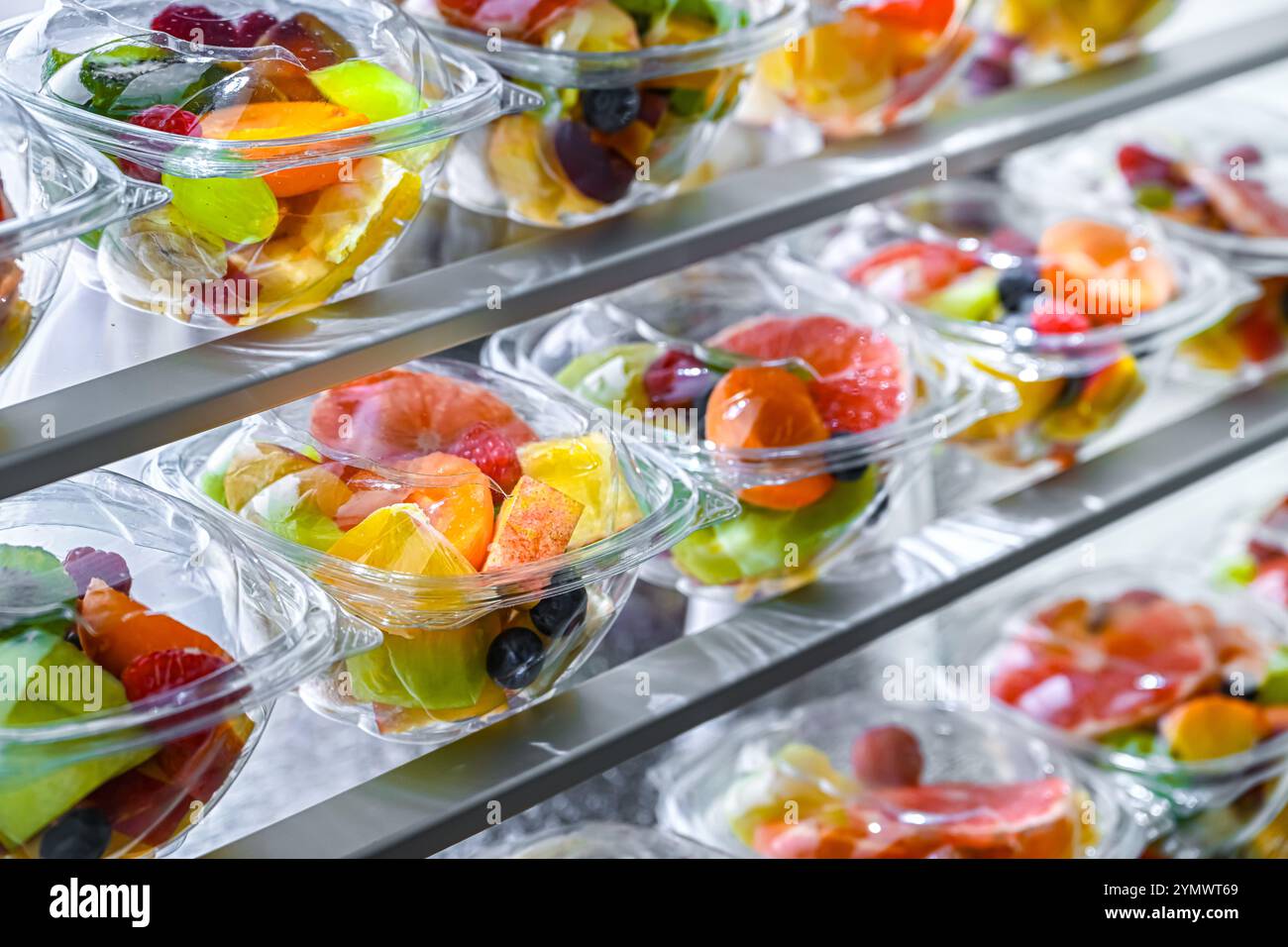 Scatole di plastica con macedonie di frutta preconfezionate, messe in vendita in un frigorifero commerciale Foto Stock