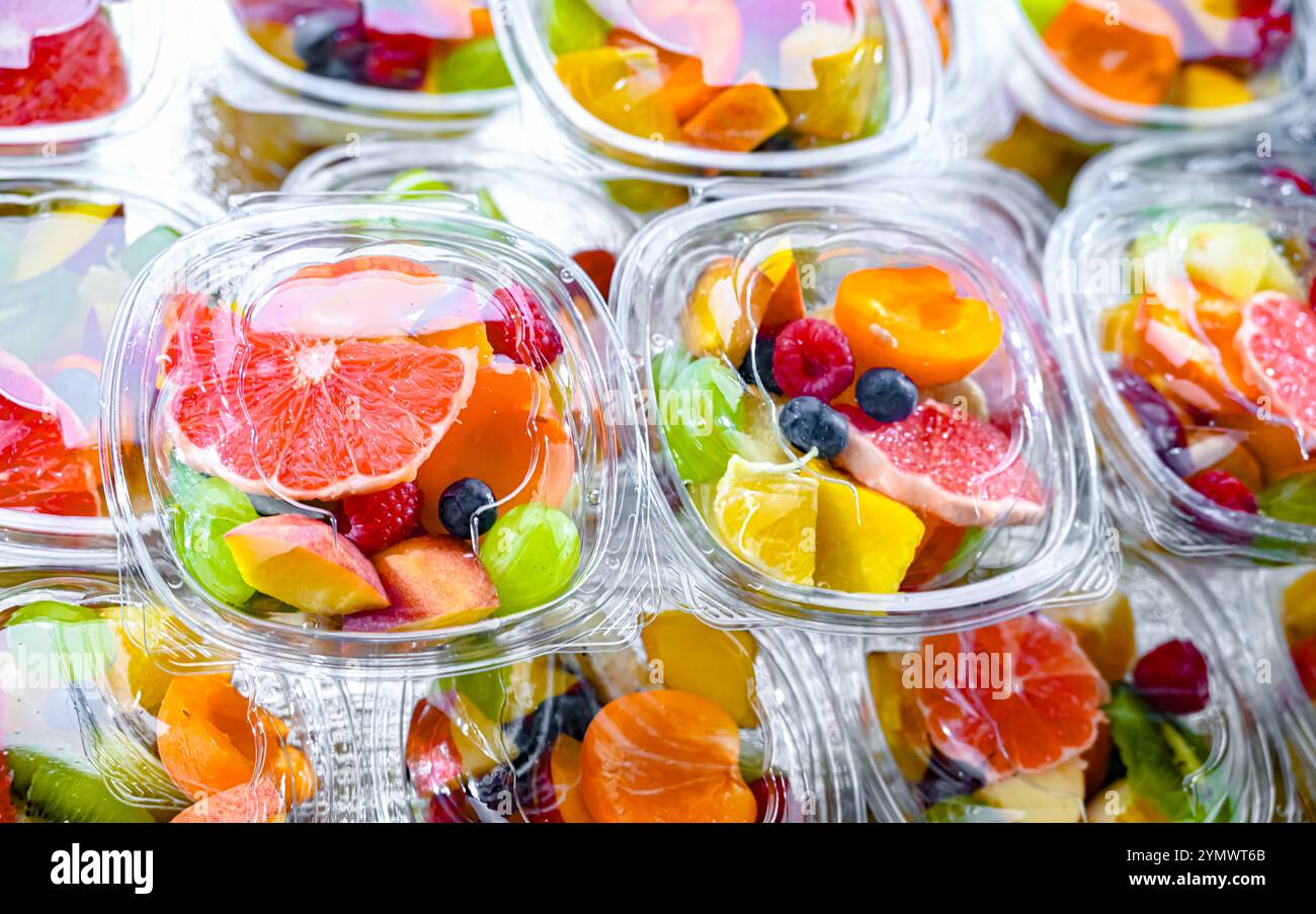 Scatole di plastica con macedonie di frutta preconfezionate, messe in vendita in un frigorifero commerciale Foto Stock