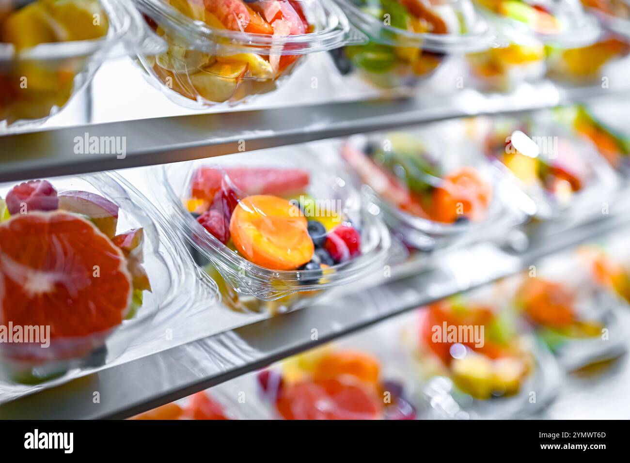 Scatole di plastica con macedonie di frutta preconfezionate, messe in vendita in un frigorifero commerciale Foto Stock
