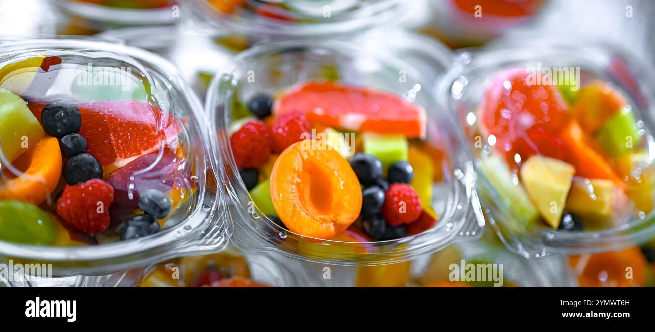Scatole di plastica con macedonie di frutta preconfezionate, messe in vendita in un frigorifero commerciale Foto Stock