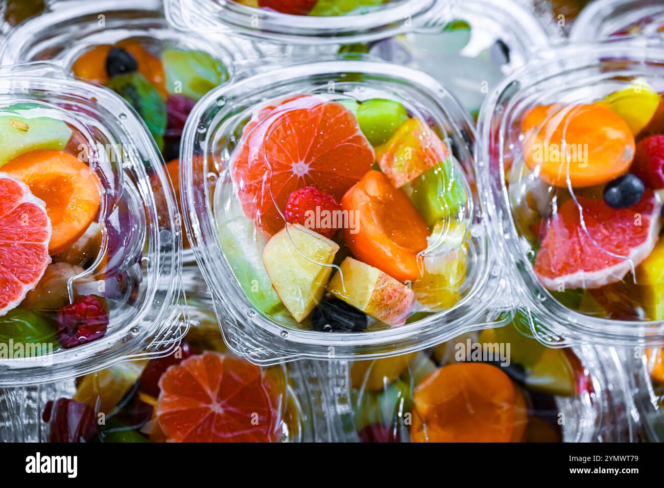 Scatole di plastica con macedonie di frutta preconfezionate, messe in vendita in un frigorifero commerciale Foto Stock