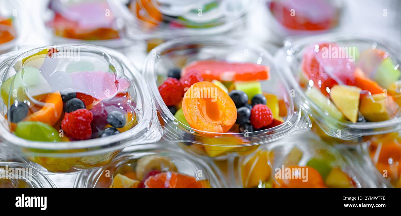 Scatole di plastica con macedonie di frutta preconfezionate, messe in vendita in un frigorifero commerciale Foto Stock