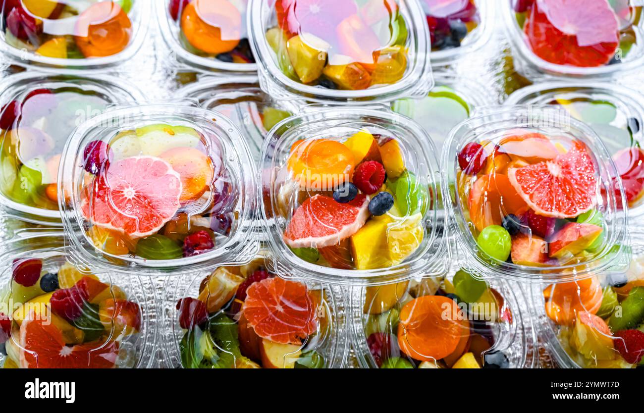 Scatole di plastica con macedonie di frutta preconfezionate, messe in vendita in un frigorifero commerciale Foto Stock