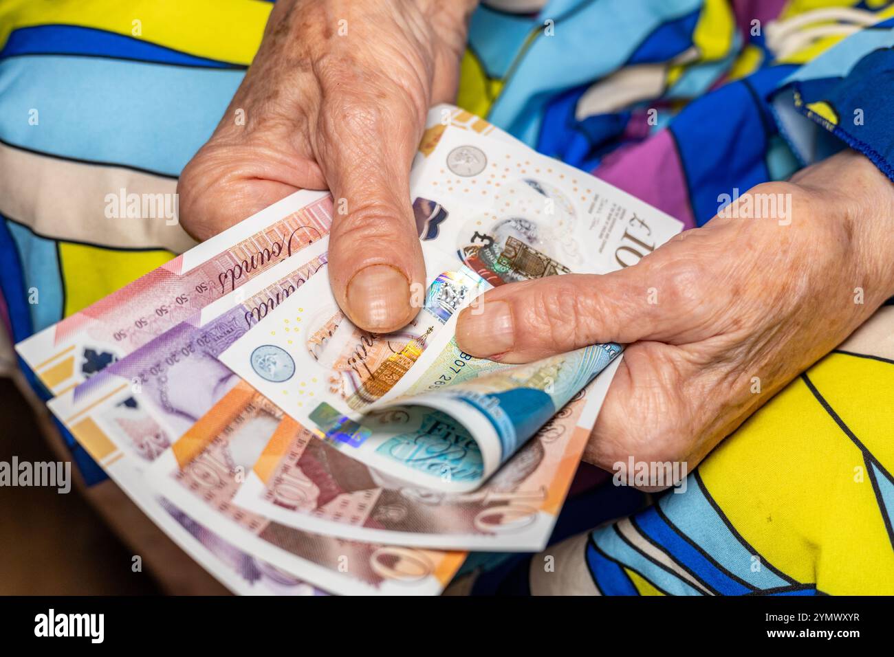 Soldi della Gran Bretagna. Donna anziana che tiene in mano sterline inglesi. Concetto finanziario ed economico. Situazione finanziaria dei pensionati nel Regno Unito Foto Stock