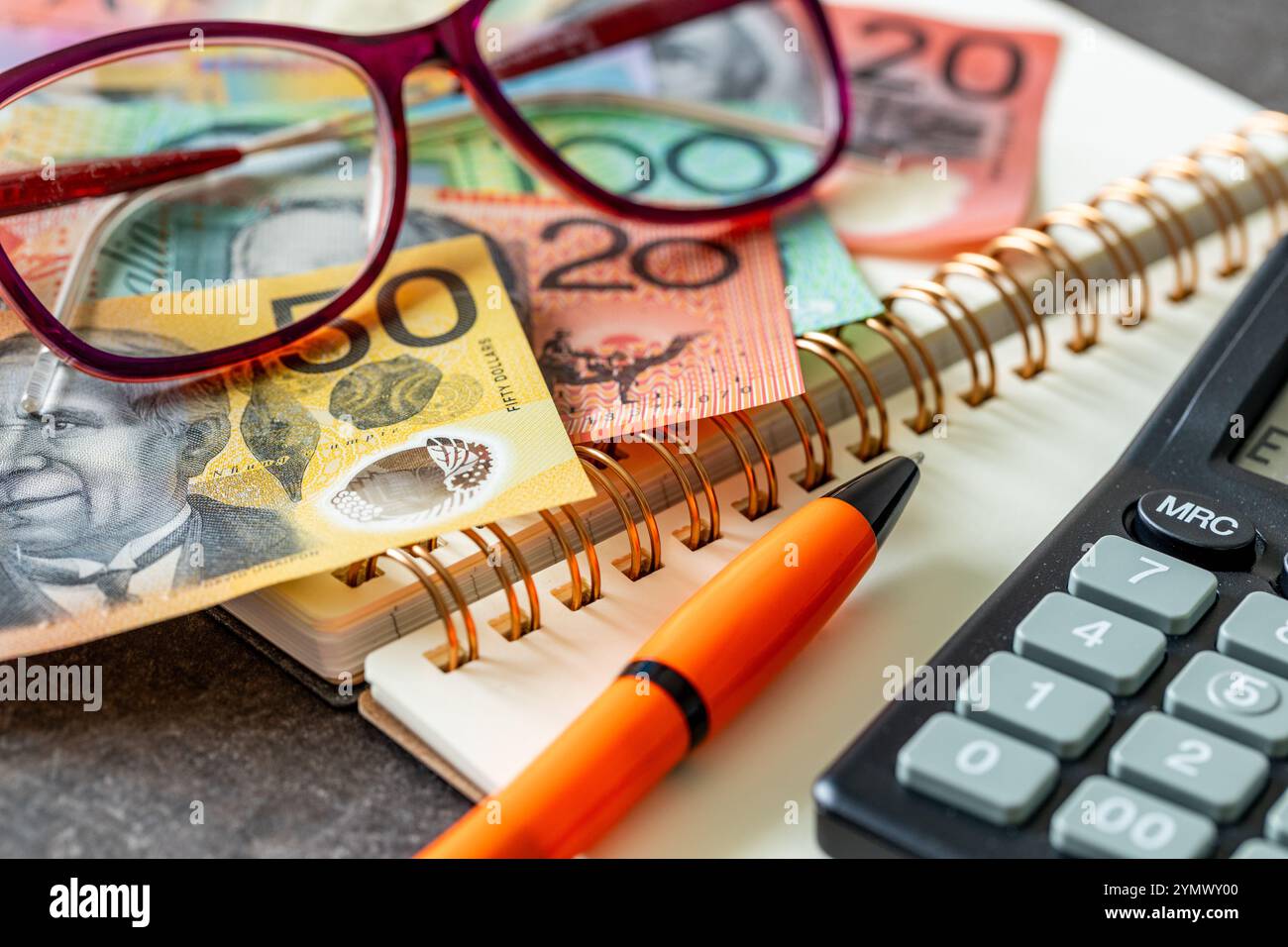 Accordo finanziario in Australia. Dollari australiani, notebook, occhiali da lettura, calcolatrice e penna, entrate e spese, bilancio di famiglia, an finanziario Foto Stock