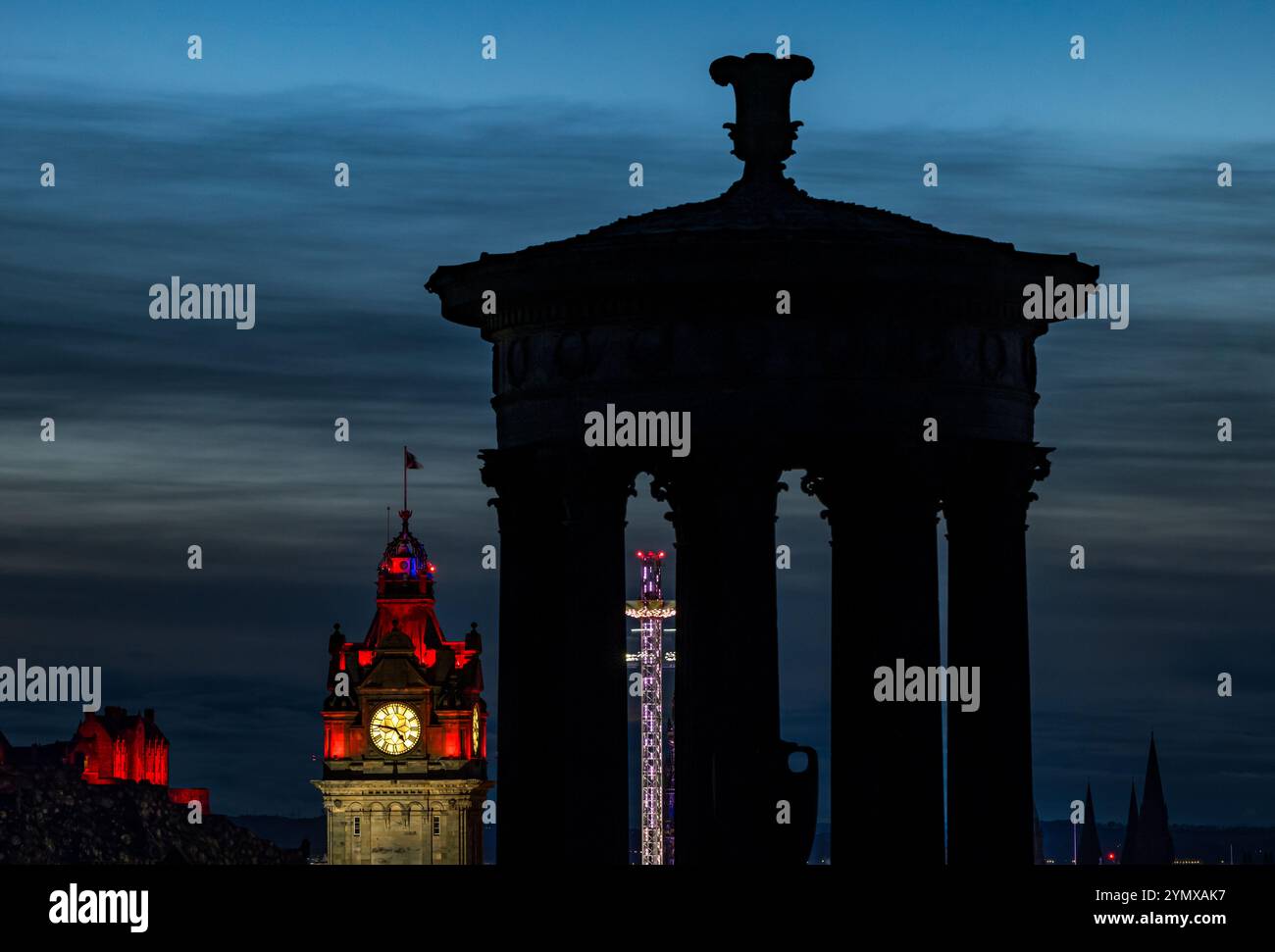 Il centro di Edimburgo di notte con la torre dell'orologio Balmoral illuminata e la sagoma del monumento Dugald Stewart a Calton Hill, Scozia, Regno Unito Foto Stock