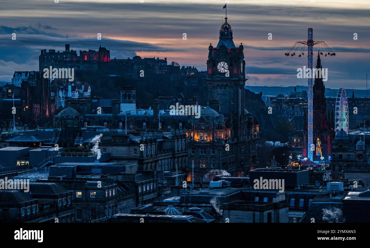 Ammira il centro di Edimburgo di notte con la torre dell'orologio Balmoral e le giostre della fiera natalizia illuminate, Scozia, Regno Unito Foto Stock