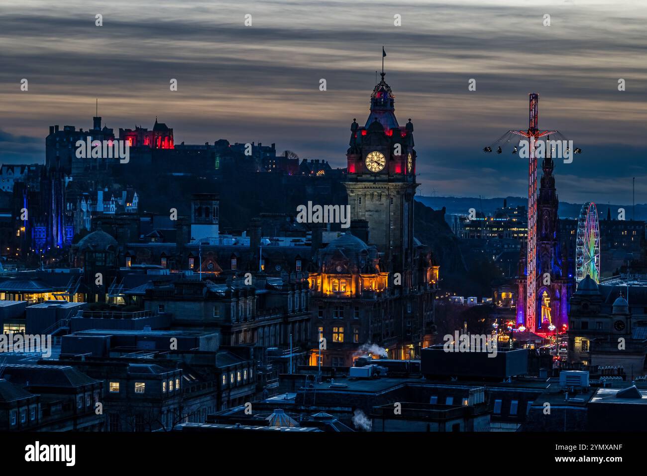 Ammira il centro di Edimburgo di notte con la torre dell'orologio Balmoral e le giostre della fiera natalizia illuminate, Scozia, Regno Unito Foto Stock
