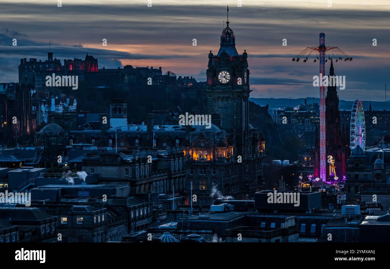 Ammira il centro di Edimburgo di notte con la torre dell'orologio Balmoral e le giostre della fiera natalizia illuminate, Scozia, Regno Unito Foto Stock