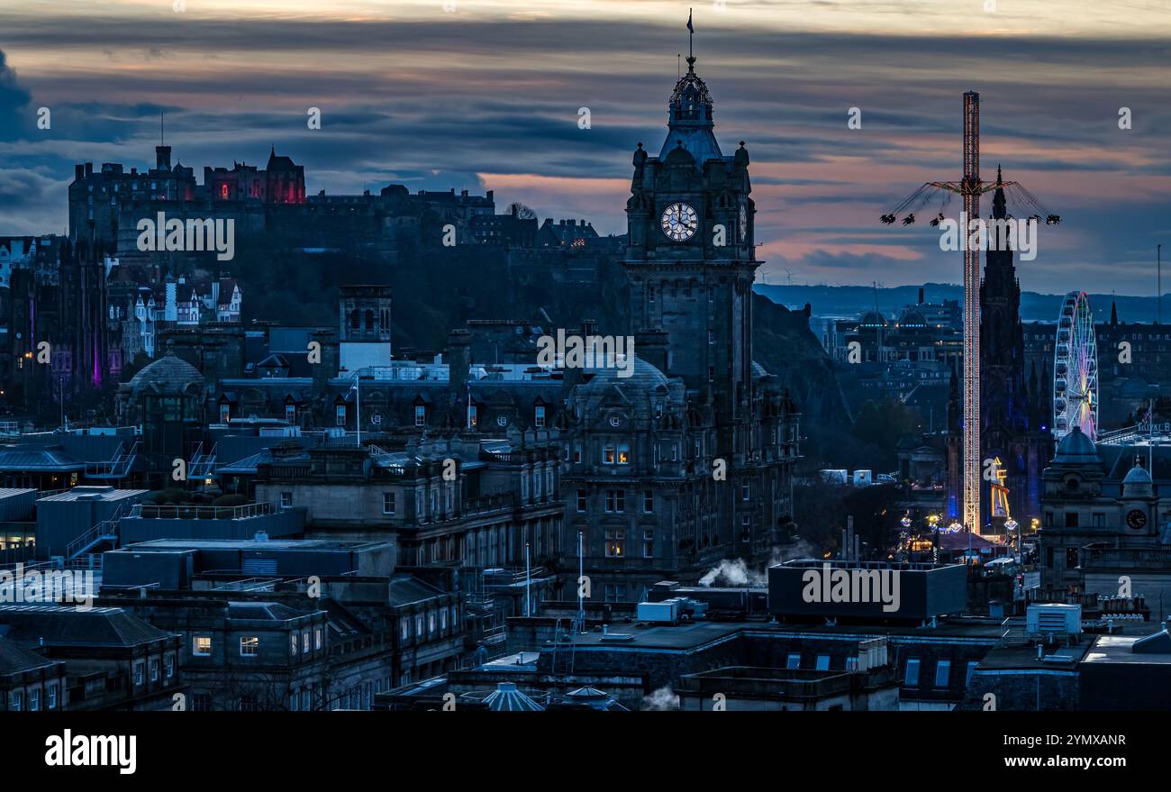 Ammira il centro di Edimburgo di notte con la torre dell'orologio Balmoral e le giostre della fiera natalizia illuminate, Scozia, Regno Unito Foto Stock