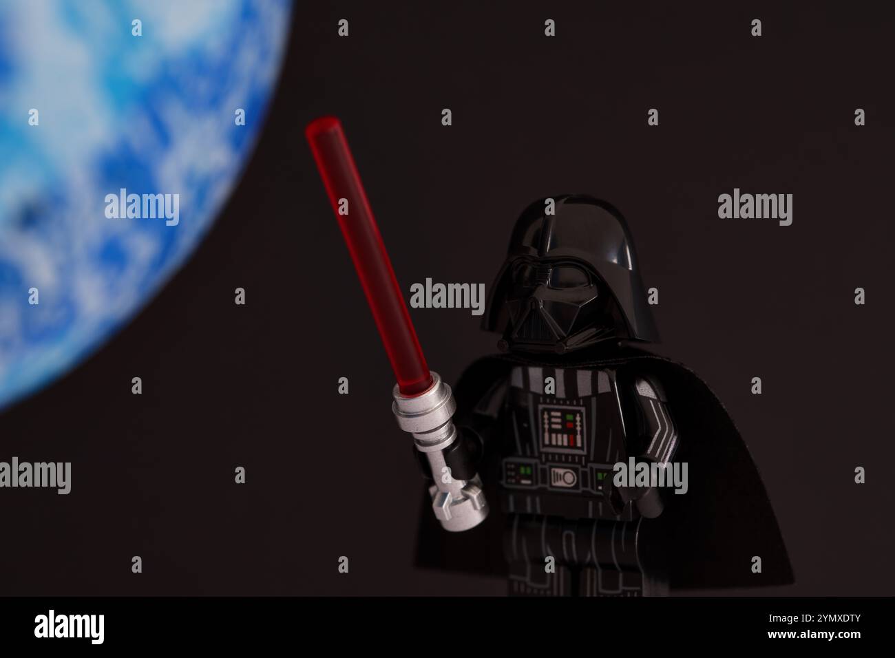 Tambov, Federazione Russa - 14 novembre 2024 Lego Dart Fener minifigure con spada laser su sfondo nero con pianeta blu Foto Stock